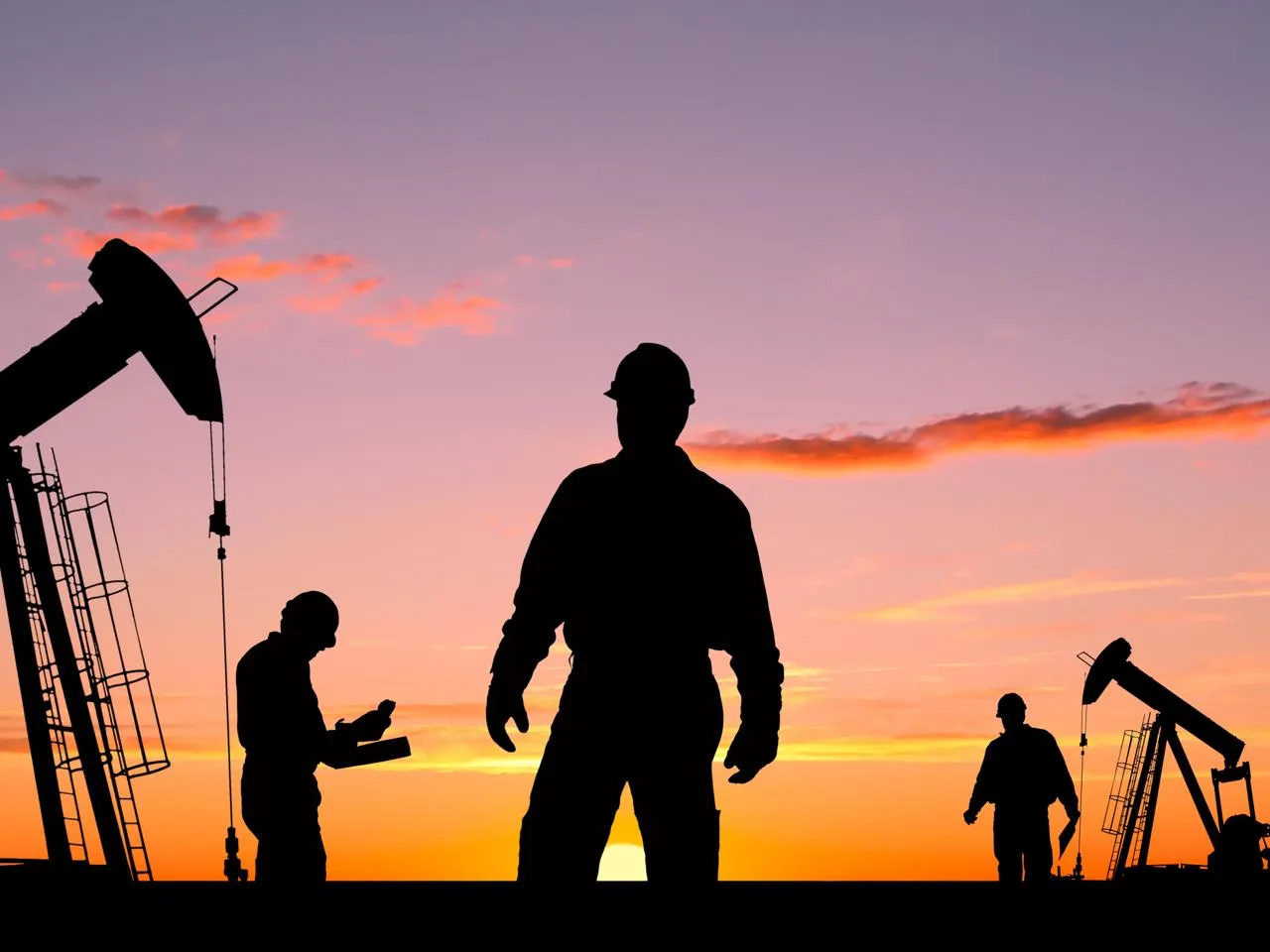 Oilfield services crew on-site at sunset with pumpjacks in the background — the kind of crew rotation Globeo houses inside 30 minutes of the pad