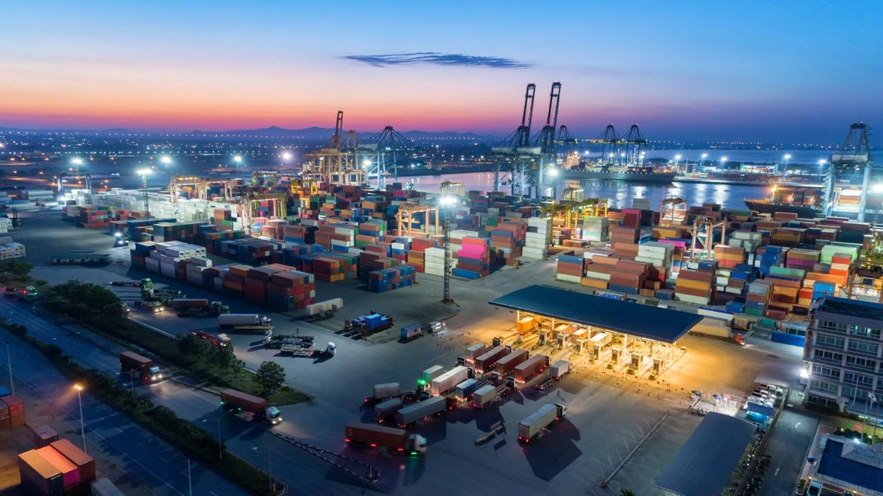 Container port at dusk during a crew change window, with Globeo concierge orchestrating shoreside layover lodging